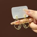 Aretes Abstractos de Silueta de Rostro con Acabado Dorado